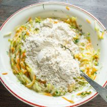 Насыпаем муку с разрыхлителем в миску с овощами. Насыпаем муку с разрыхлителем в миску с овощами.